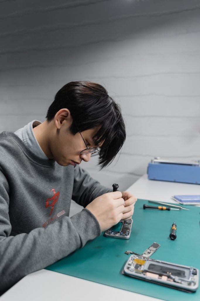 pexels photo 6755050 1 Focused young technician repairing a smartphone indoors at a workstation.